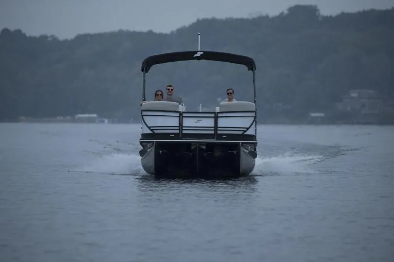 Slide: The Image of 2023 Starcraft SLS 5 pontoon boat cruising on a lake with passengers. - 5