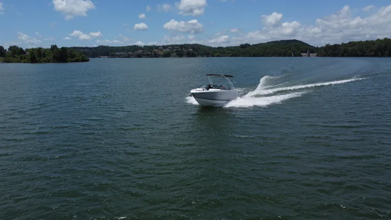 Slide: The Image of 2023 Cobalt R6 boat cruising on a scenic lake under a clear blue sky. - 8
