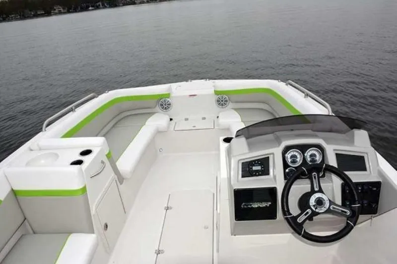 Slide: The Image of 2023 Starcraft SVX 171 boat interior with steering wheel and seating on a lake. - 12