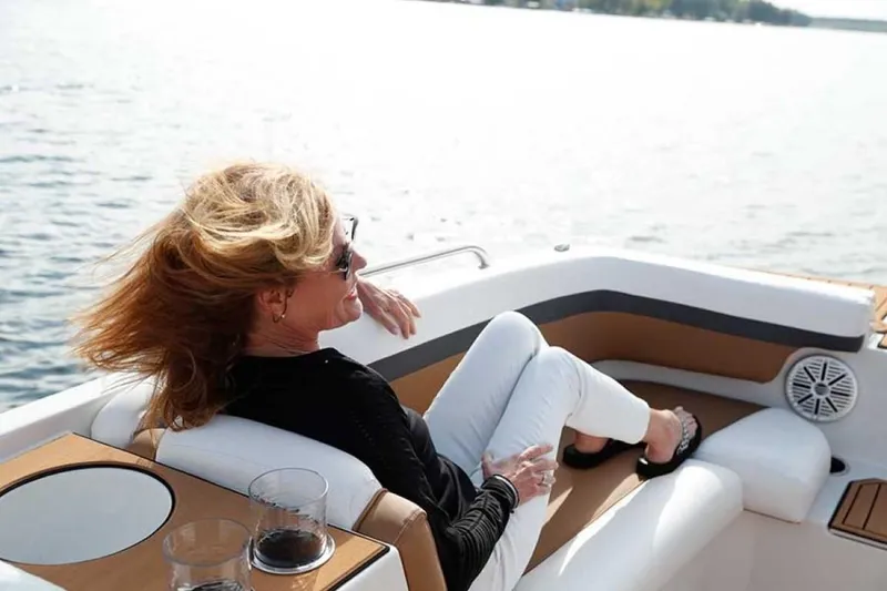 Slide: The Image of Woman relaxing on a 2023 Starcraft SVX 171 boat with drinks by the water. - 6