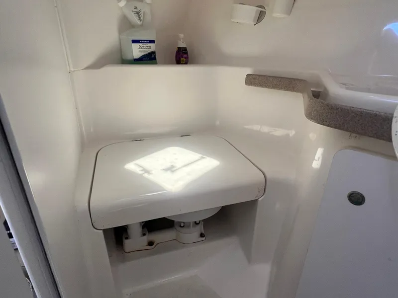 Slide: The Image of 1996 Silverton 310 Express boat bathroom with compact toilet and toiletries. - 12
