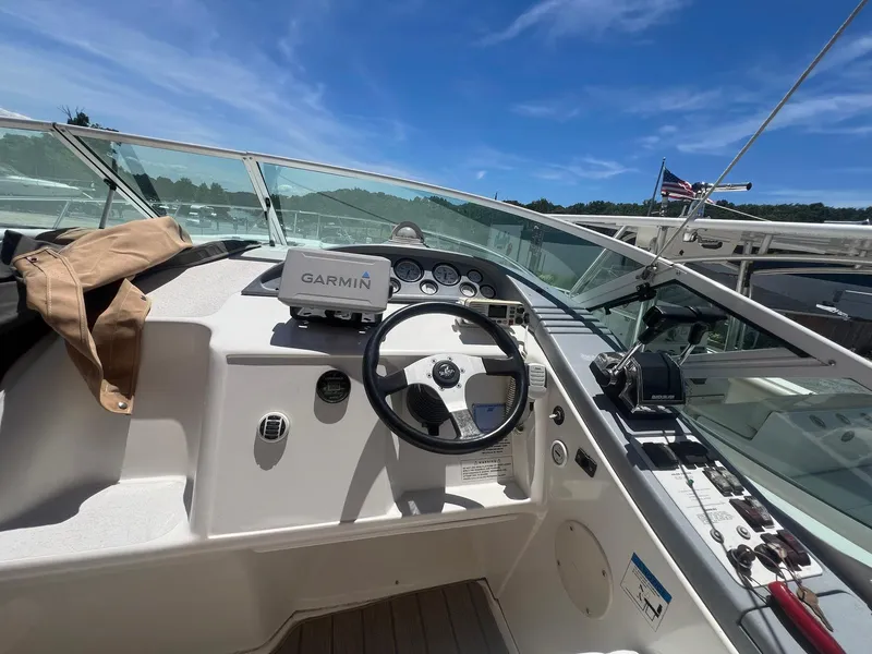 Slide: The Image of 1996 Silverton 310 Express boat cockpit with Garmin navigation, steering wheel, and clear blue sky. - 6