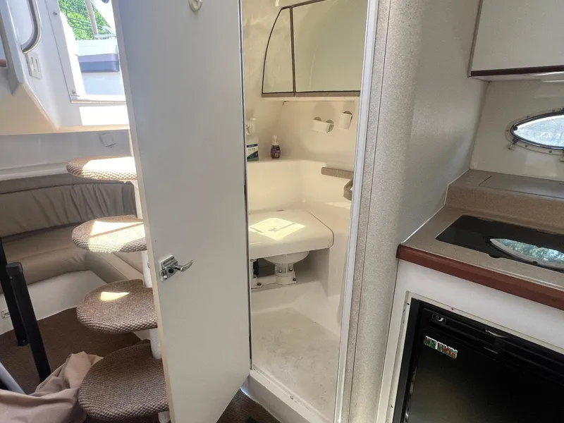 Slide: The Image of 1996 Silverton 310 Express cabin interior with kitchenette, seating, and bathroom. - 9