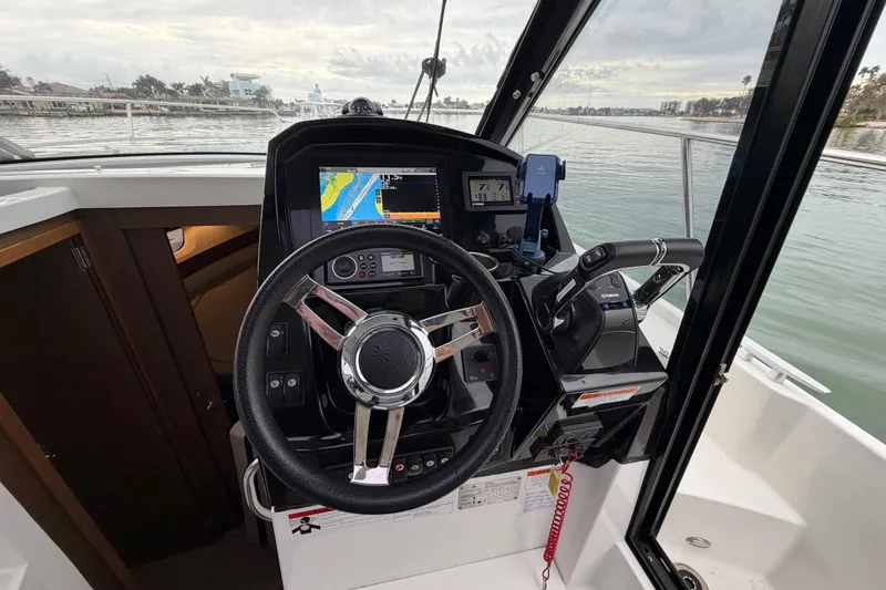 Slide: The Image of Helm of 2019 Jeanneau NC 895 boat with navigation equipment and steering wheel. - 12