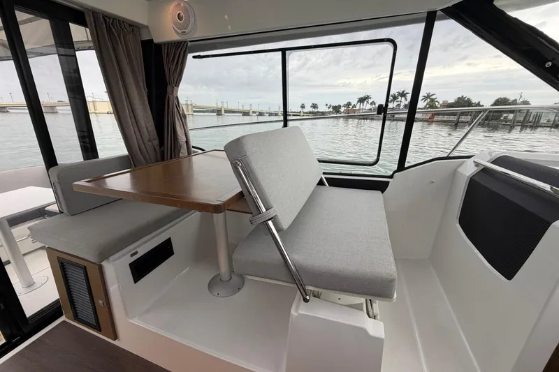 Slide: The Image of Interior of 2019 Jeanneau NC 895 boat with seating and table, overlooking water. - 14