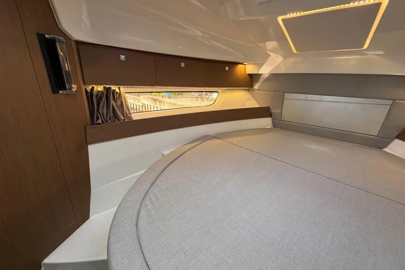 Slide: The Image of 2019 Jeanneau NC 895 cabin interior with modern wood finish and cozy bedding. - 18