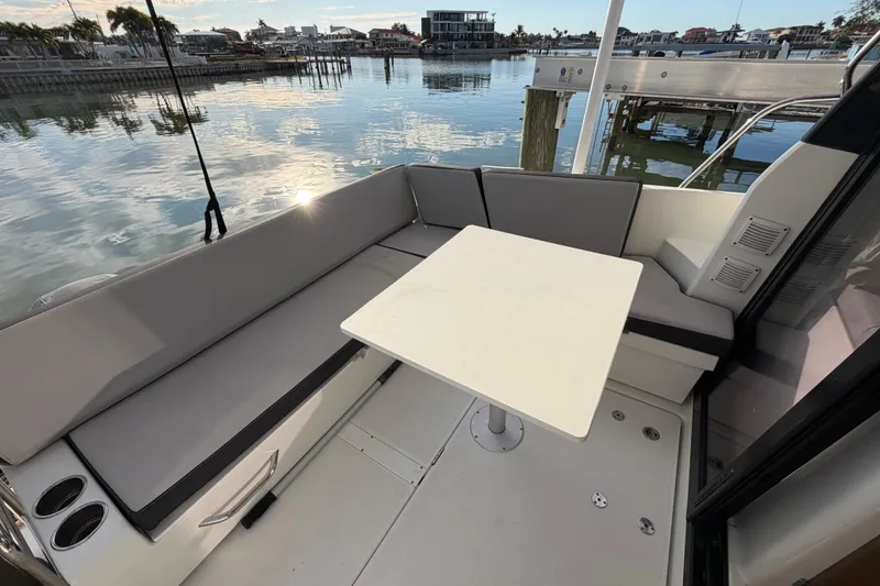 Slide: The Image of 2019 Jeanneau NC 895 boat interior with seating and table, docked by calm waters. - 24