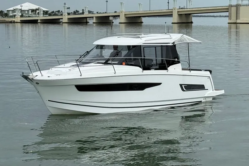 Slide: The Image of 2019 Jeanneau NC 895 boat on calm water near a bridge. - 6