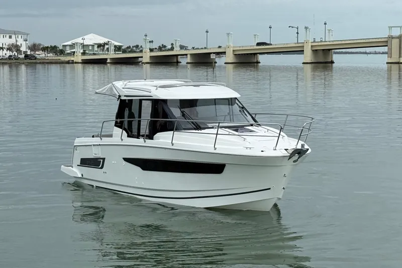 Slide: The Image of 2019 Jeanneau NC 895 boat on calm water near a bridge. - 7