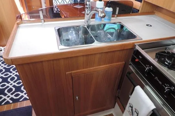 Slide: The Image of 2008 Catalina 350 MkII yacht kitchen with dual sink and wooden cabinetry. - 12