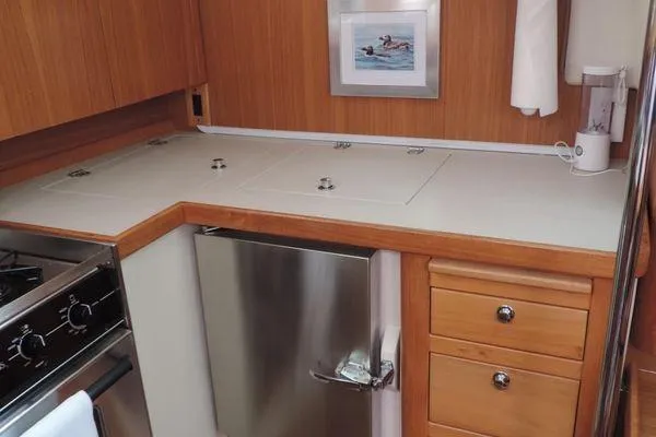 Slide: The Image of 2008 Catalina 350 MkII yacht kitchen with stainless steel appliances and wooden cabinetry. - 13