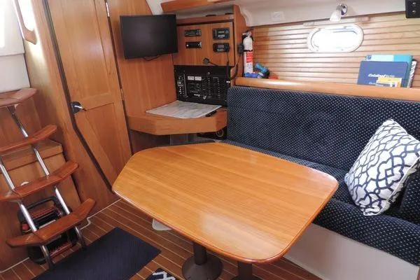 Slide: The Image of 2008 Catalina 350 MkII interior with wooden table, seating, and navigation equipment. - 16