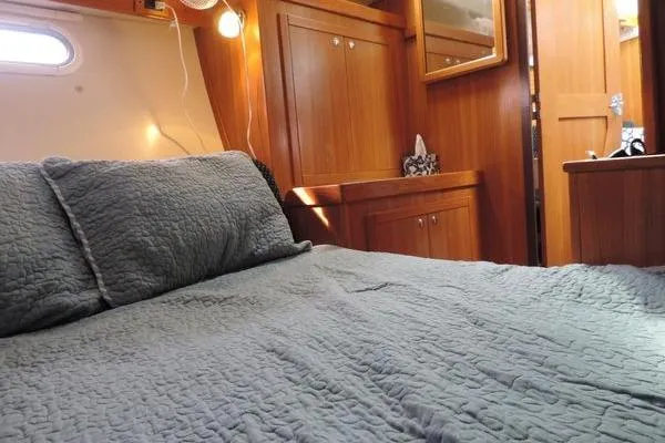 Slide: The Image of Cozy cabin interior of 2008 Catalina 350 MkII sailboat with wooden furnishings and bed. - 22