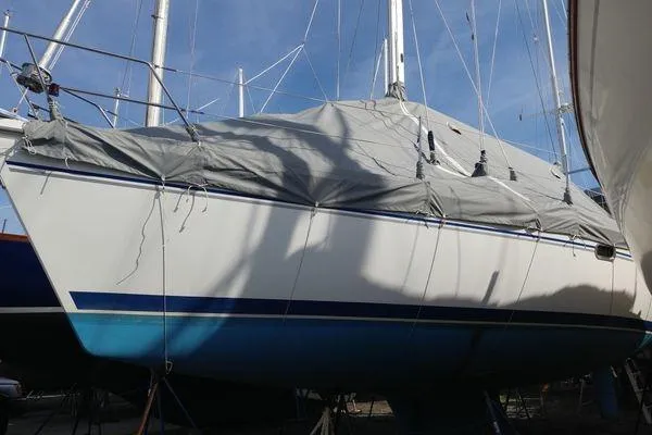 Slide: The Image of 2008 Catalina 350 MkII sailboat covered and docked, with blue hull and gray tarp. - 33