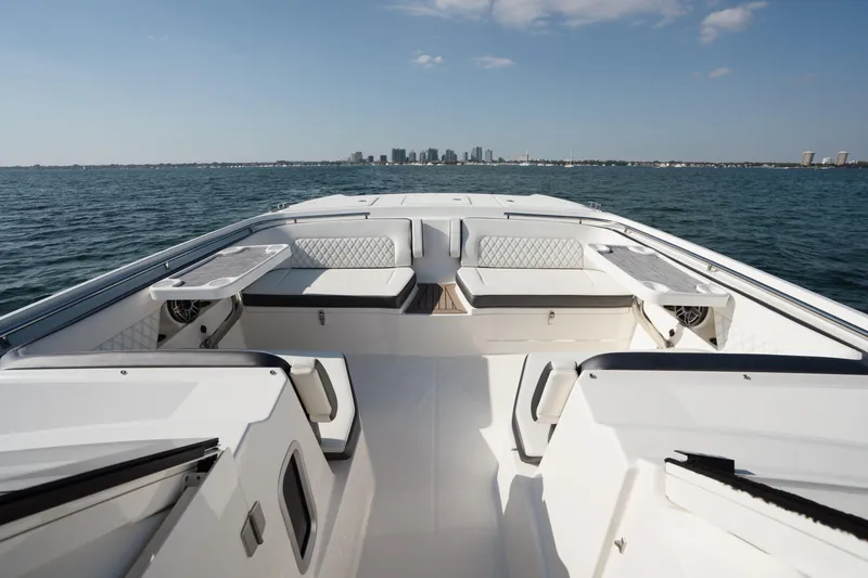 Slide: The Image of 2024 World Cat 400 DC-X boat interior with seating, ocean view, and city skyline. - 13
