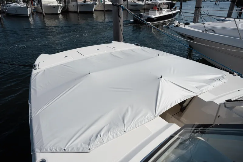 Slide: The Image of 2024 World Cat 400 DC-X boat with a white cover docked at a marina. - 15