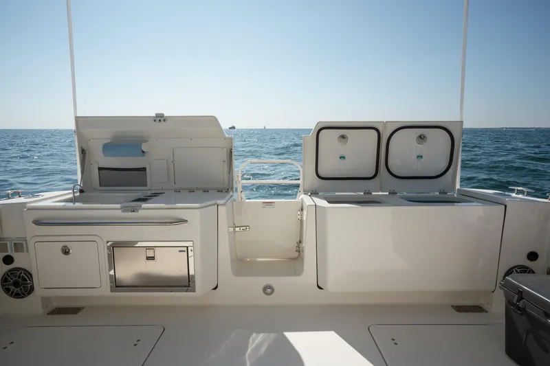Slide: The Image of 2024 World Cat 400 DC-X boat deck with open storage compartments, ocean view. - 22