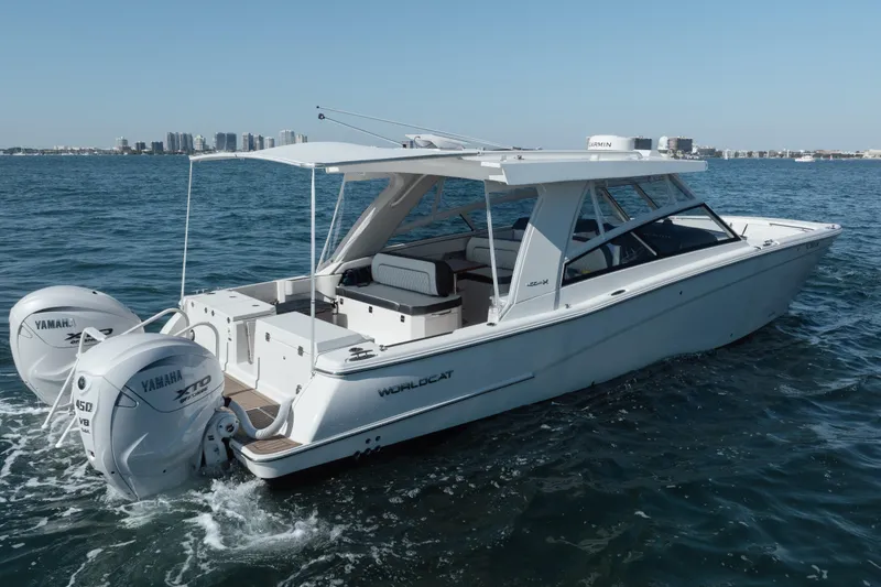 Slide: The Image of 2024 World Cat 400 DC-X boat cruising on open water with twin Yamaha engines. - 7