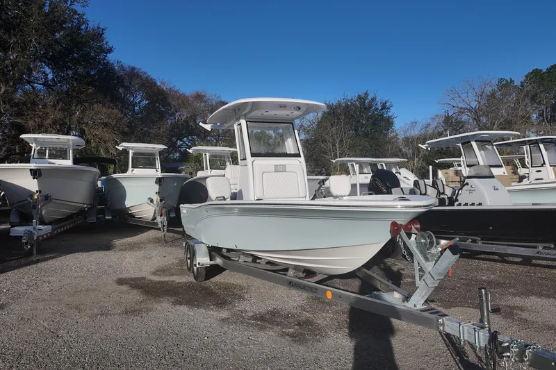 Slide: The Image of 2026 Sea Fox 231 Bay Fox boat on trailer, surrounded by other boats, under clear blue sky. - 4