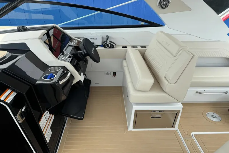Slide: The Image of 2026 Cruisers Yachts 34 GLS I/O helm with modern controls and beige seating. - 10