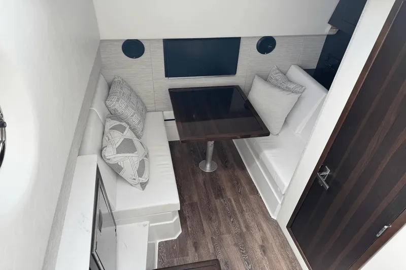 Slide: The Image of 2026 Cruisers Yachts 34 GLS I/O interior with elegant seating and wooden table. - 25