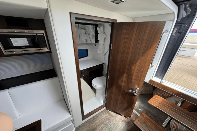 Slide: The Image of Interior of 2026 Cruisers Yachts 34 GLS I/O, featuring a compact bathroom and seating area. - 30