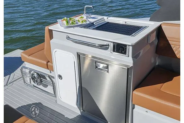 Slide: The Image of Manufacturer Provided Image: Outdoor kitchen on 2026 Cruisers Yachts 34 GLS I/O, featuring grill and sink by the water. - 18