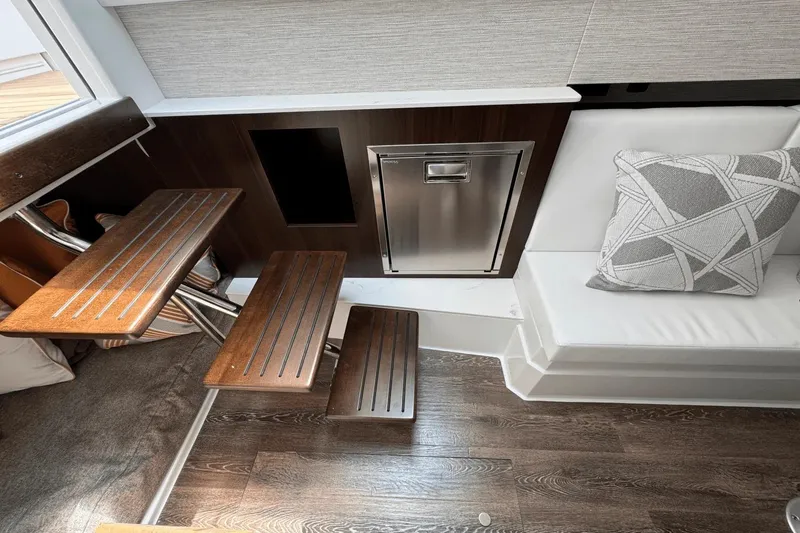 Slide: The Image of Interior of 2026 Cruisers Yachts 34 GLS I/O with wooden steps and modern seating. - 24