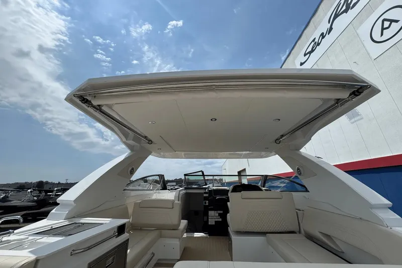 Slide: The Image of 2026 Cruisers Yachts 34 GLS I/O interior with open canopy under blue sky. - 6
