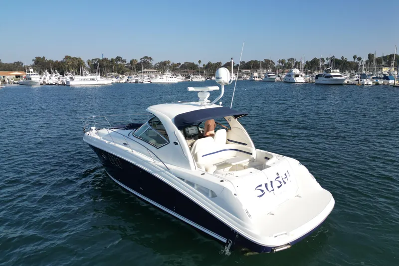 The Image of 2006 Sea Ray 38 Sundancer yacht cruising in a marina with other boats. - 0