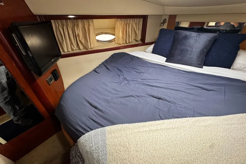 Slide: The Image of Cozy cabin interior of 2006 Sea Ray 38 Sundancer with bed and TV. - 11