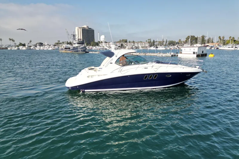 Slide: The Image of 2006 Sea Ray 38 Sundancer yacht cruising in a marina with clear blue water. - 5