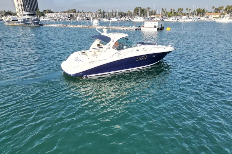 Slide: The Image of 2006 Sea Ray 38 Sundancer yacht cruising in a marina with clear blue water. - 6