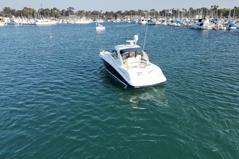 Slide: The Image of 2006 Sea Ray 38 Sundancer yacht cruising in a marina with other boats. - 8