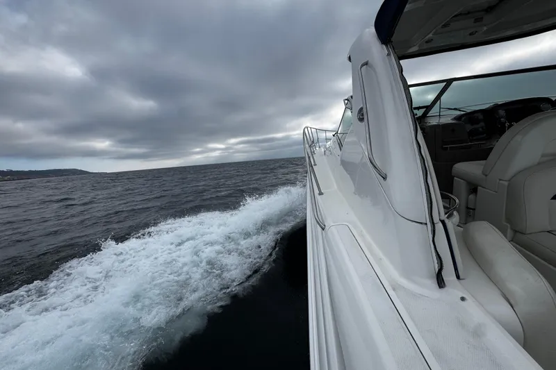Slide: The Image of 2006 Sea Ray 38 Sundancer cruising on open water under cloudy skies. - 9