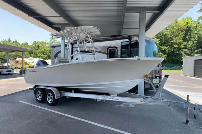 The Image of 2014 Sportsman Heritage 211 Center Console boat on trailer in covered storage. - 0