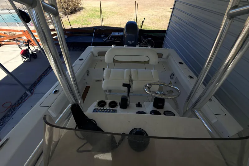 Slide: The Image of 2014 Sportsman Heritage 211 Center Console boat in storage, showcasing helm and T-top structure. - 37