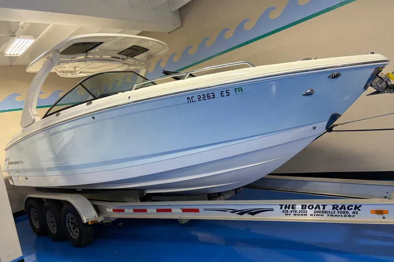 The Image of 2021 Chaparral 30 Surf boat on trailer in indoor showroom. - 0