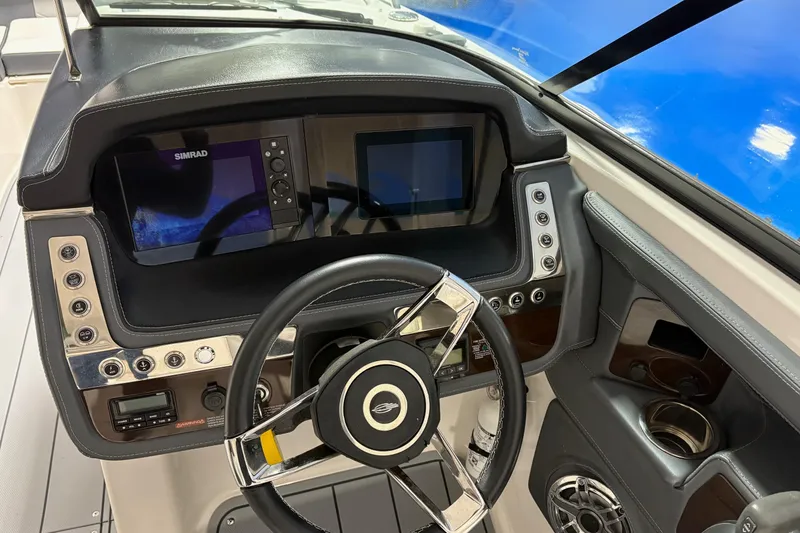 Slide: The Image of 2021 Chaparral 30 Surf boat dashboard with steering wheel and digital displays. - 15