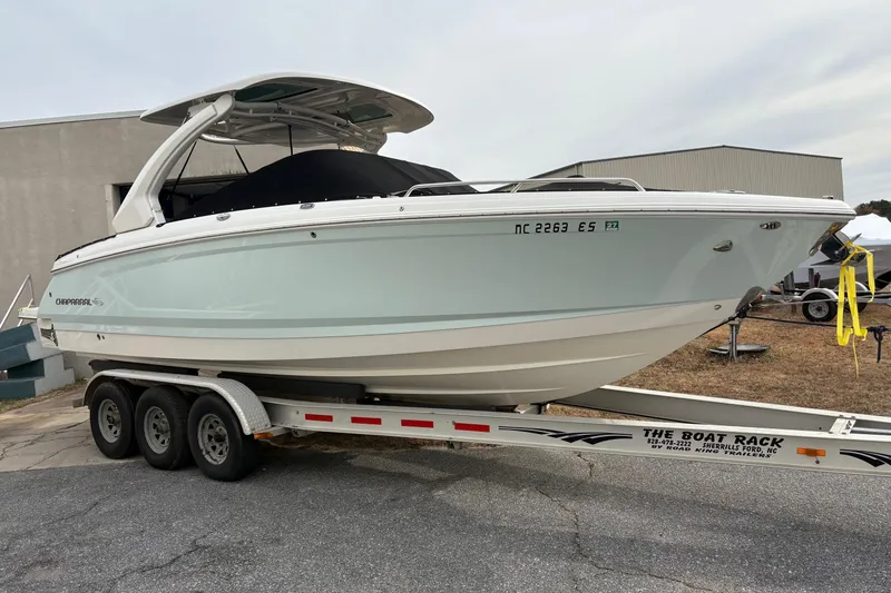 Slide: The Image of 2021 Chaparral 30 Surf boat on a trailer, displayed outdoors. - 3