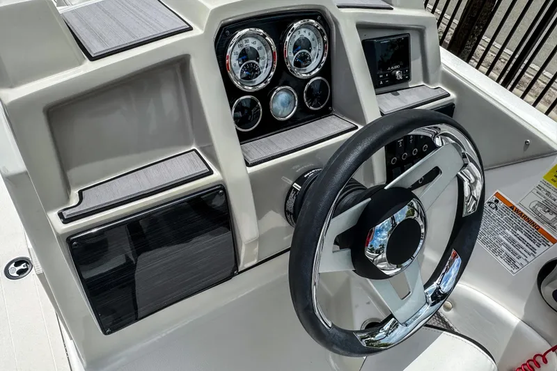Slide: The Image of 2024 Starcraft SVX 211 OB boat dashboard with steering wheel and gauges. - 10