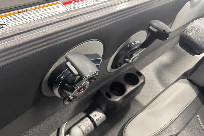 Slide: The Image of Interior controls of 2026 Lund 1975 Tyee boat, featuring dual levers and cup holders. - 19