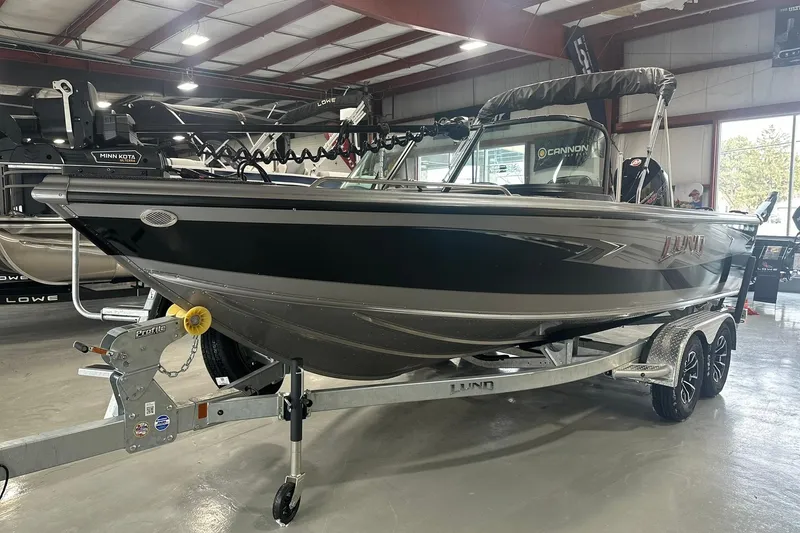 Slide: The Image of 2026 Lund 1975 Tyee boat in showroom, black and silver design, on a trailer. - 30