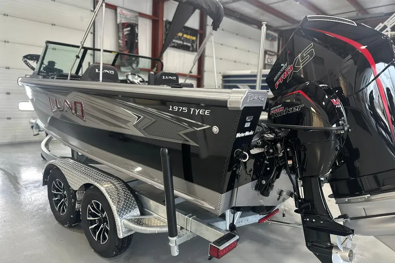 Slide: The Image of 2026 Lund 1975 Tyee boat on trailer with powerful outboard motor in a garage setting. - 31