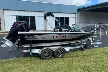 Slide: The Image of 2026 Lund 1975 Tyee boat with powerful outboard motor in a garage setting. - 4