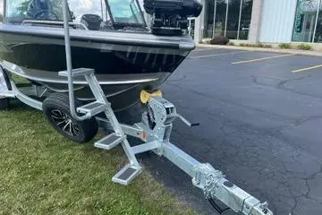 Slide: The Image of 2026 Lund 1975 Tyee boat with dual Mercury outboard motors in a showroom. - 5