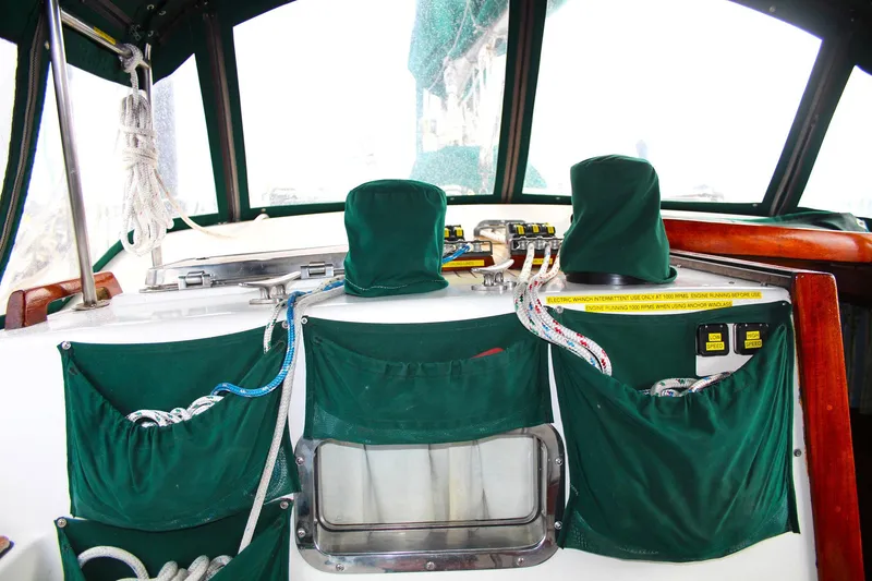 Slide: The Image of Interior of a 1990 Slocum 43 sailboat cockpit with green covers and ropes. - 10