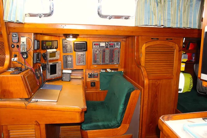 Slide: The Image of Navigation station inside a 1990 Slocum 43 sailboat, featuring control panels and equipment. - 13