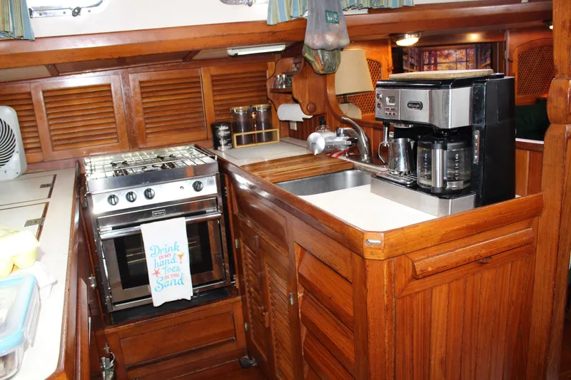 Slide: The Image of Cozy 1990 Slocum 43 yacht kitchen with stove, sink, and coffee maker. - 16