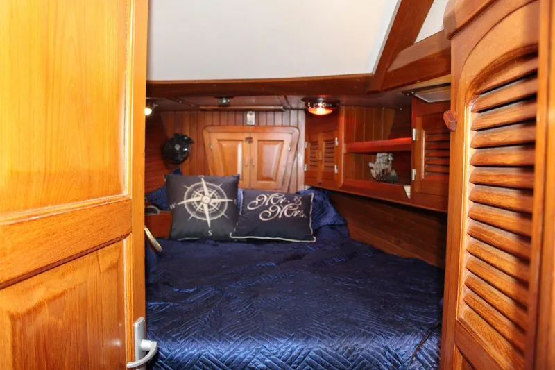 Slide: The Image of Cozy cabin interior of 1990 Slocum 43 sailboat with nautical-themed pillows and wooden finish. - 20
